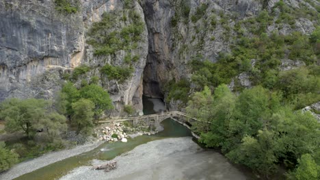 portitsa gorge grevena greece, aerial pullback shot, stone bridge rocky mountain and river view