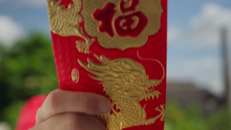 asian man giving hong bao red envelope for chinese new year tradition