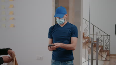 delivery guy with protection face mask and gloves delivering takeaway food box