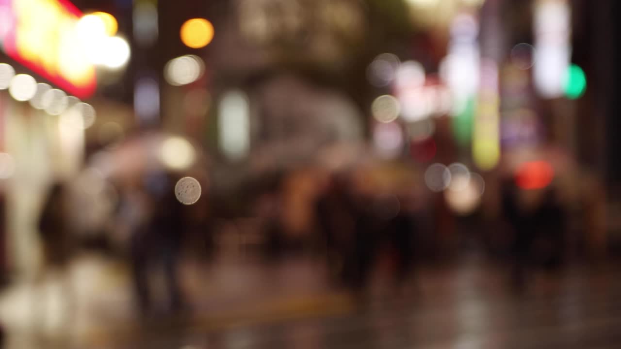 gente caminando desenfocada en la calle en shinjuku por la noche día lluvioso de mano