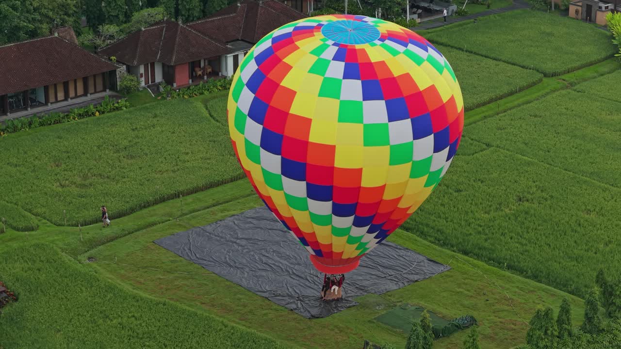 Balão de ar quente colorido pousando nos campos de arroz de Bali.