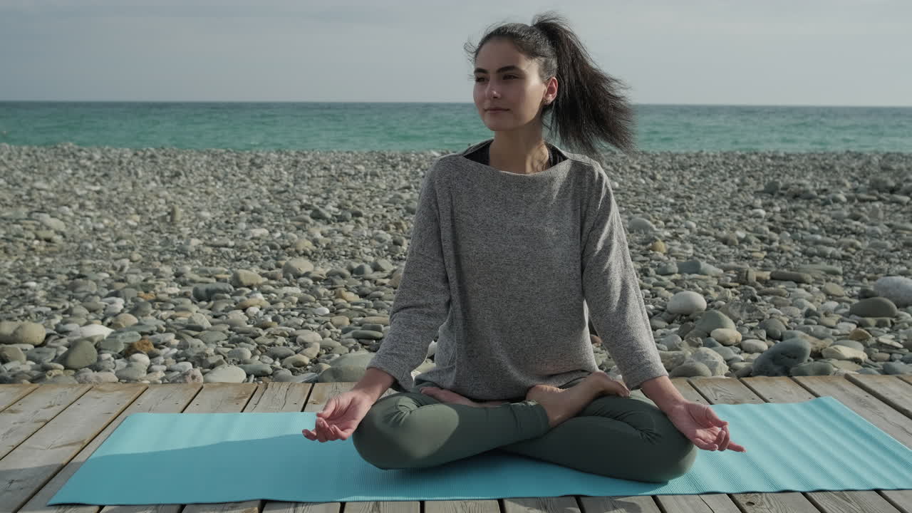 mujer practicando yoga en la playa