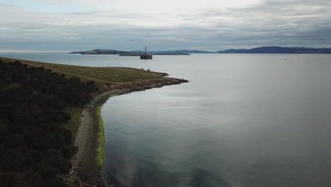 Drohne-Pfanne-Um-Felsige-Küste-Mit-Bohrinsel-Im-Hintergrund-Australien