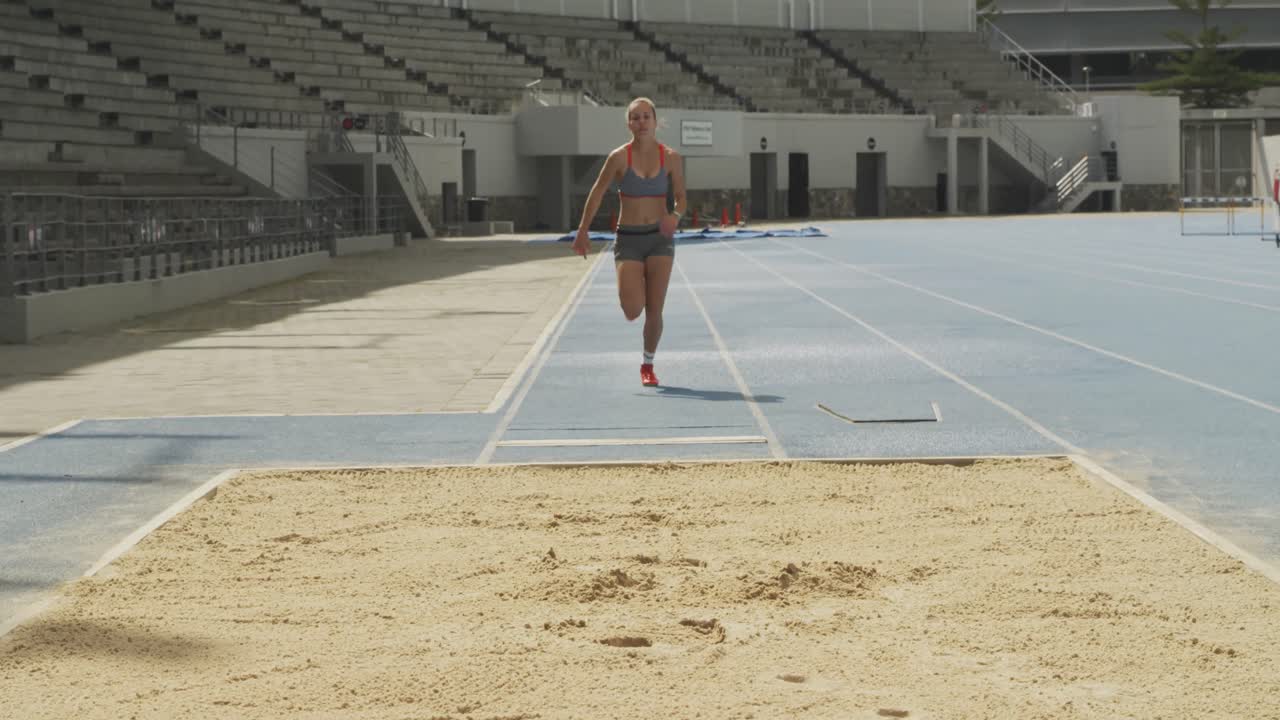 vista frontal de un atleta caucásico haciendo un salto de longitud