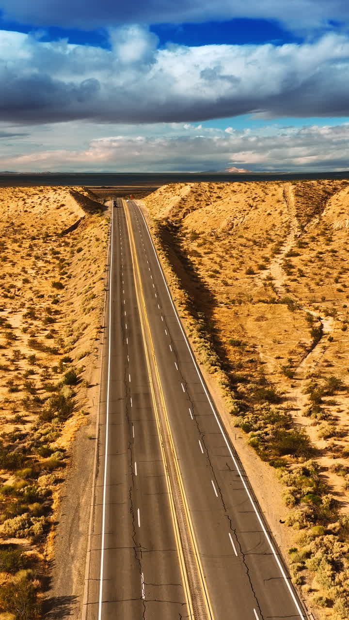 Footage above the highways in Nevada desert, USA. Gorgeous cloudscape in the sky at backdrop. Top view. Vertical video