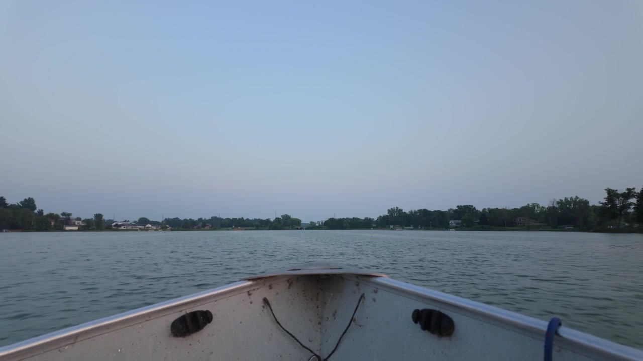 Ripresa POV con gimbal che si inclina verso il basso su una barca da pesca in movimento durante la prima serata in Minnesota. 4K.