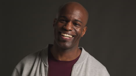 studio portrait of excited man celebrating good news winning money against black background