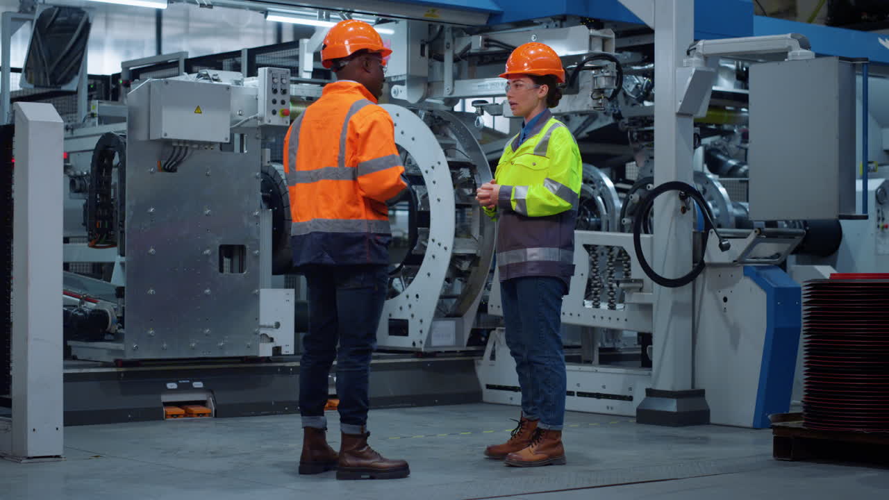Mechaniker-Partner schütteln Hände nahe riesiger moderner Industrieanlage.