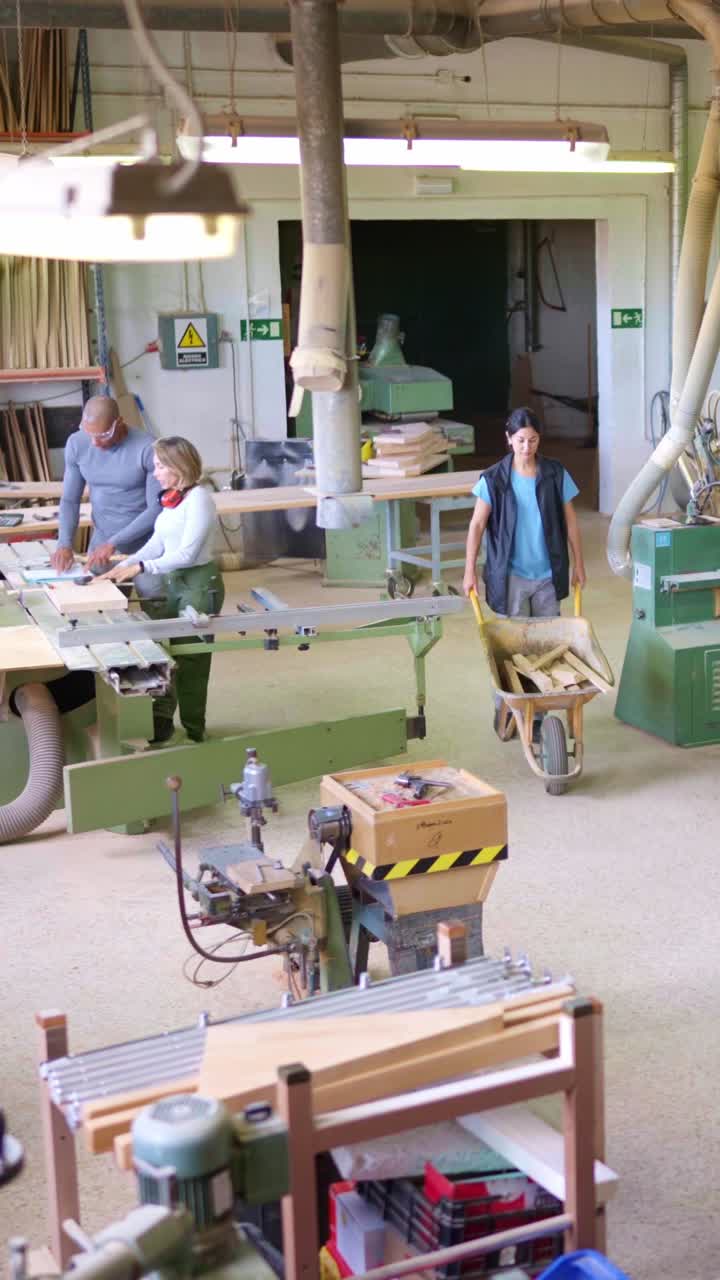 Team of Woodworkers Operating Machinery in a Busy Carpentry Workshop