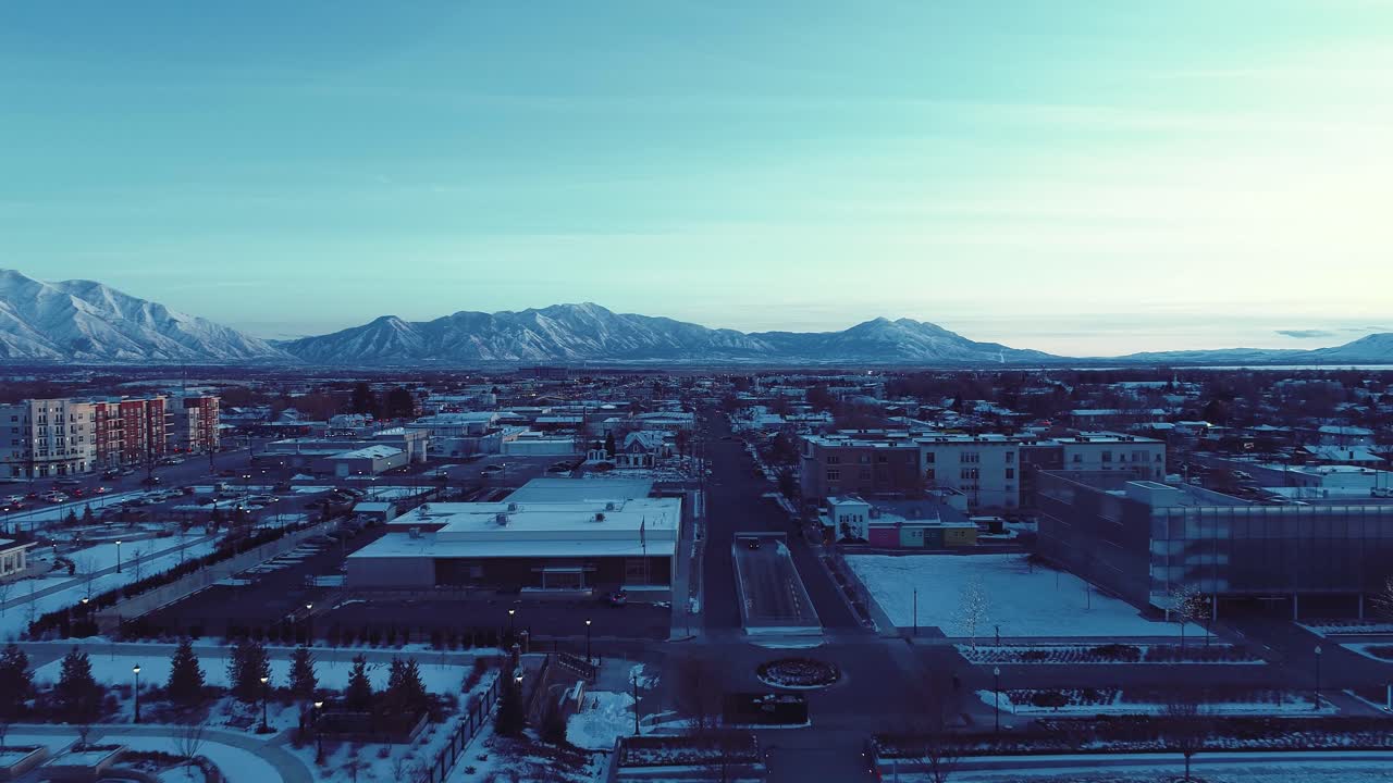 황혼의 푸른 시간 동안 프로보 유타의 건물 꼭대기를 휩쓸고 햇빛이 언덕 위로 간신히 정점에 도달합니다 - 건물을 통해 공중 돌리