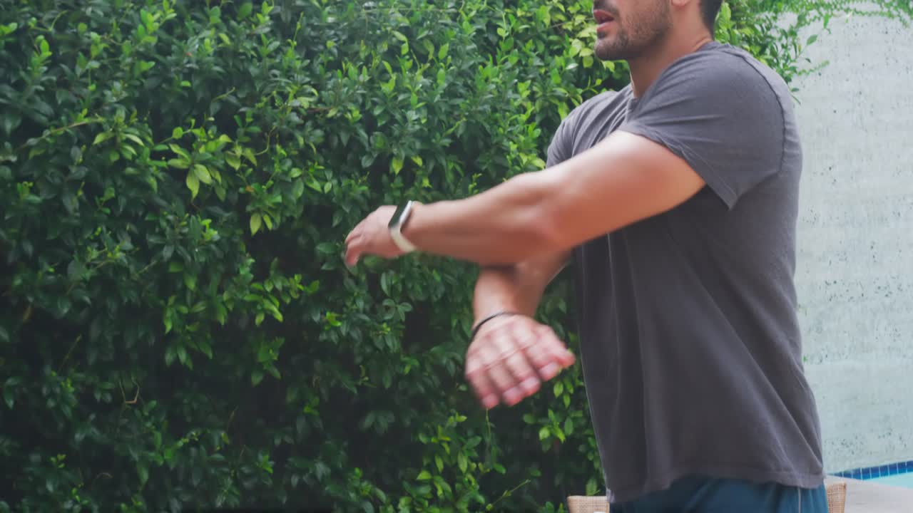 Uomo in abbigliamento sportivo che si sta riscaldando sul patio, avvicinandosi ai manubri esagonali, con spazio per il testo.