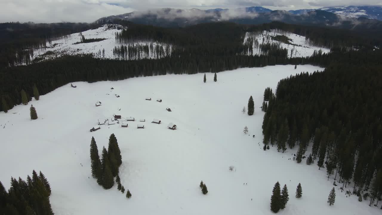 naturaleza capturada con un dron con el paisaje, montañas cubiertas de nieve a la hora dorada al amanecer con bosques y colinas circundantes capturadas en eslovenia sobre el bosque pokljuka sobre un pueblo