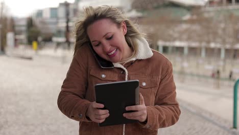 Mujer-Madura-Sonriente-Sosteniendo-Tableta-Y-Hablando-Por-Teléfono