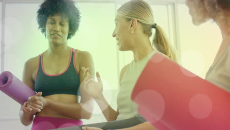 holding yoga mats and chatting, women with bokeh light animation over them