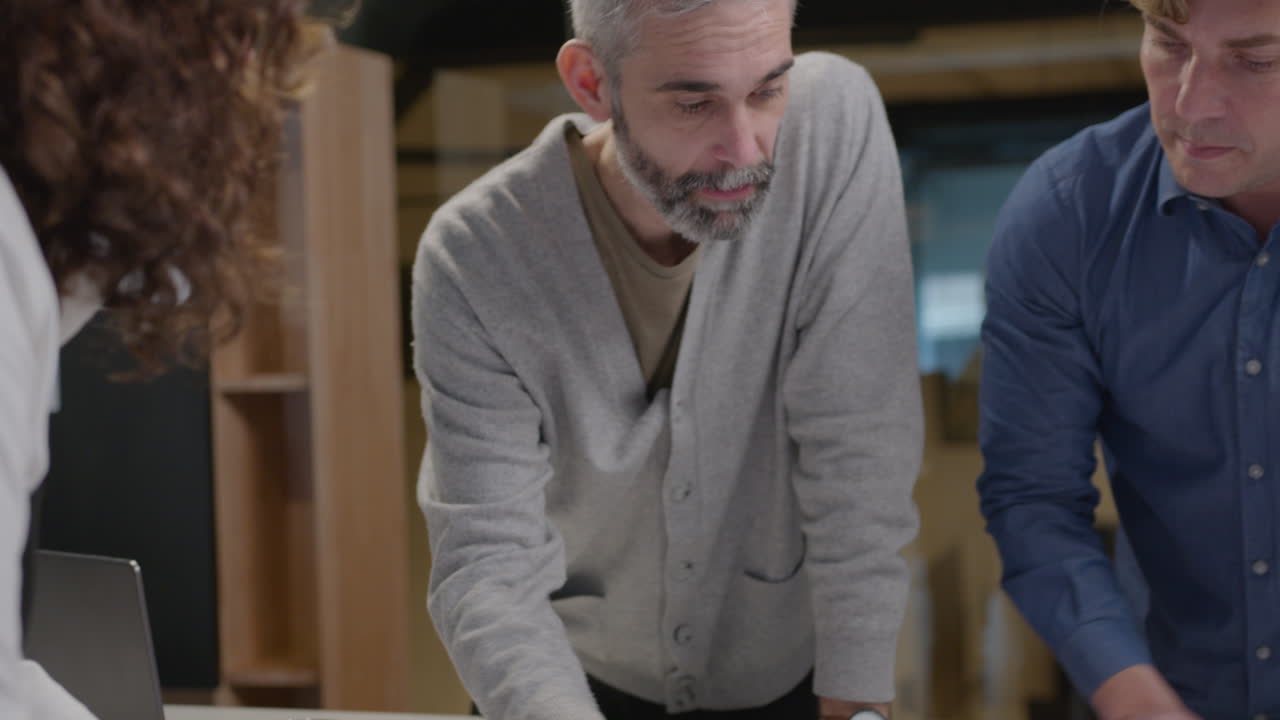 Group of Architects Discussing Papers at Office Table