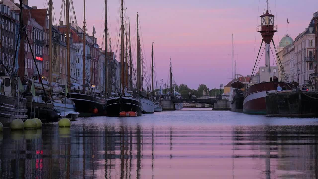 A beautiful sunset over the Nyhaven canal in Copenhagen. Filmed on a clear summer evening in one of Denmark's most iconic streets.