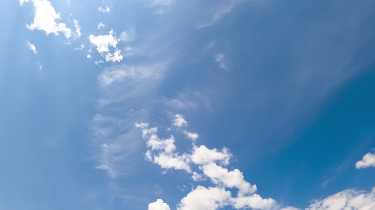 Beautiful light cirrus clouds in the atmosphere. Little clouds lit with hot summer sun. Low angle view. Timelapse.