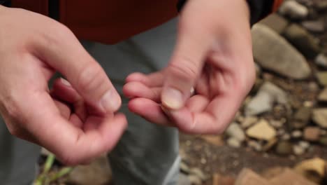 toma de mano de un pescador con mosca atando nudos para atar a los señuelos de pesca