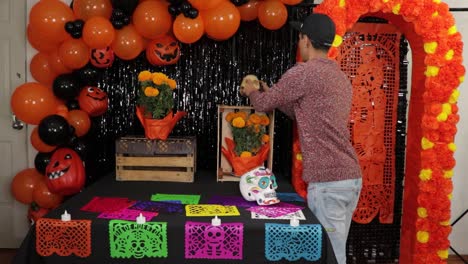 Placing-realistic-skull-decoration-on-decorated-Día-de-muertos-altar