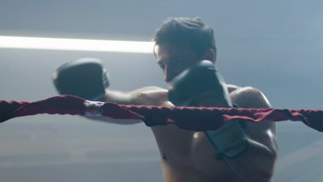 young male boxer doing shadow fight while training