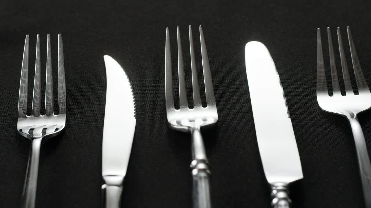Table Setting with Silverware on Black Tablecloth