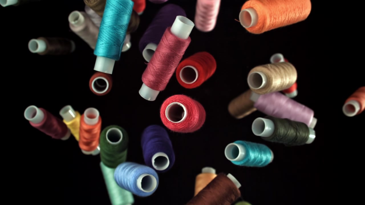 Colorful Spools of Thread Falling in Slow Motion