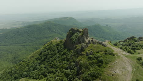 The-medieval-Azeula-Fortress-and-a-foggy,-green-wilderness-in-the-background