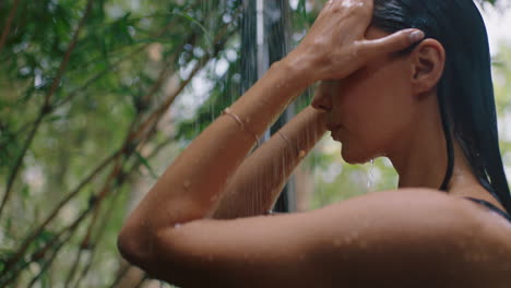 attractive woman in shower wearing bikini washing body cleansing skin with refreshing water enjoying natural beauty spa showering outdoors in nature