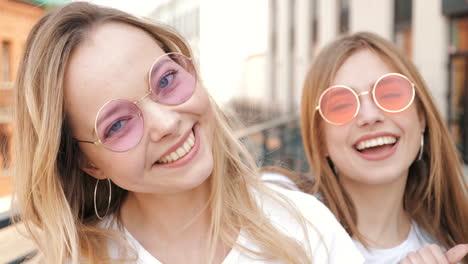 two happy women with pink glasses