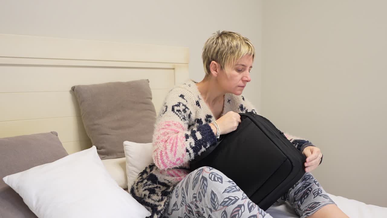 Donna che prepara la valigia in camera da letto