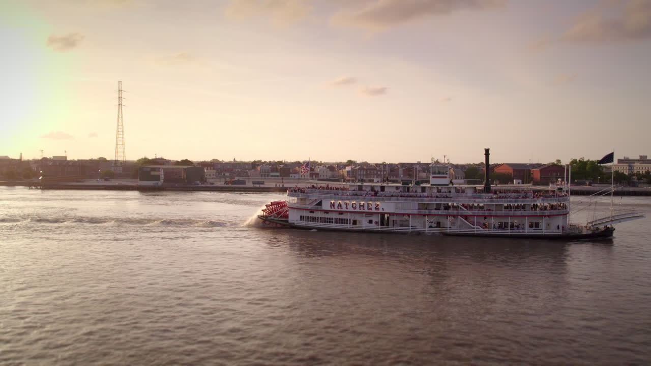 Aerial follow alongside Natchez Steamboat at sunset