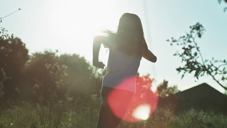girl running in a field at sunset