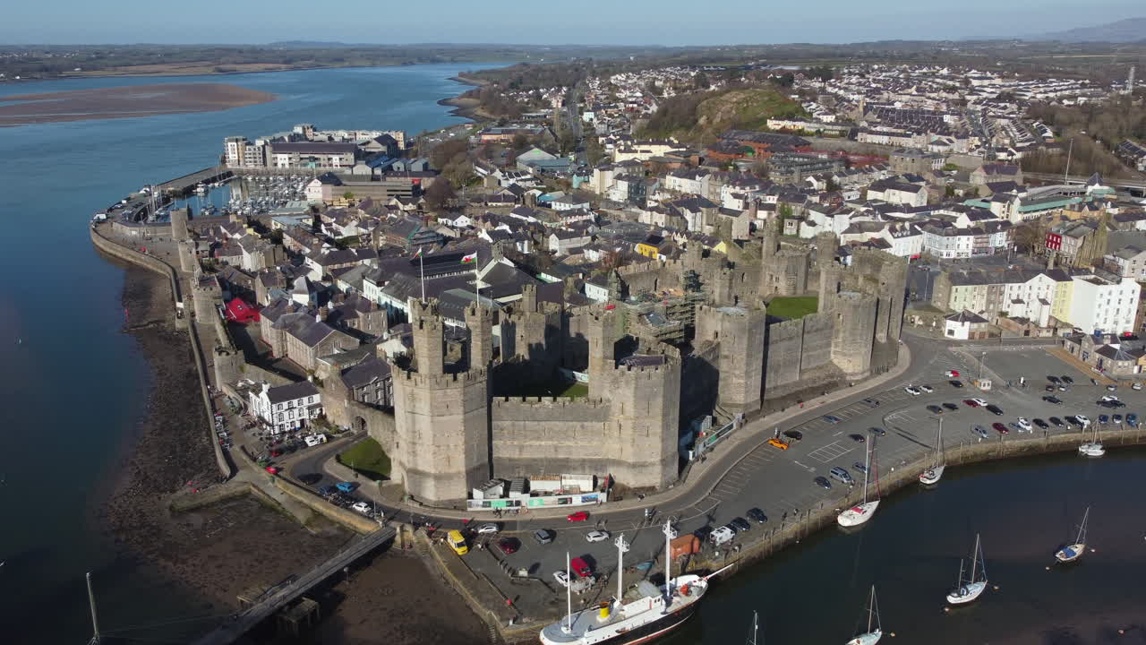 화창한 날에 카나번 성의 공중 전망, 성 주위를 오른쪽에서 왼쪽으로 날아다니는, 영국 노스 웨일즈, 기네드
