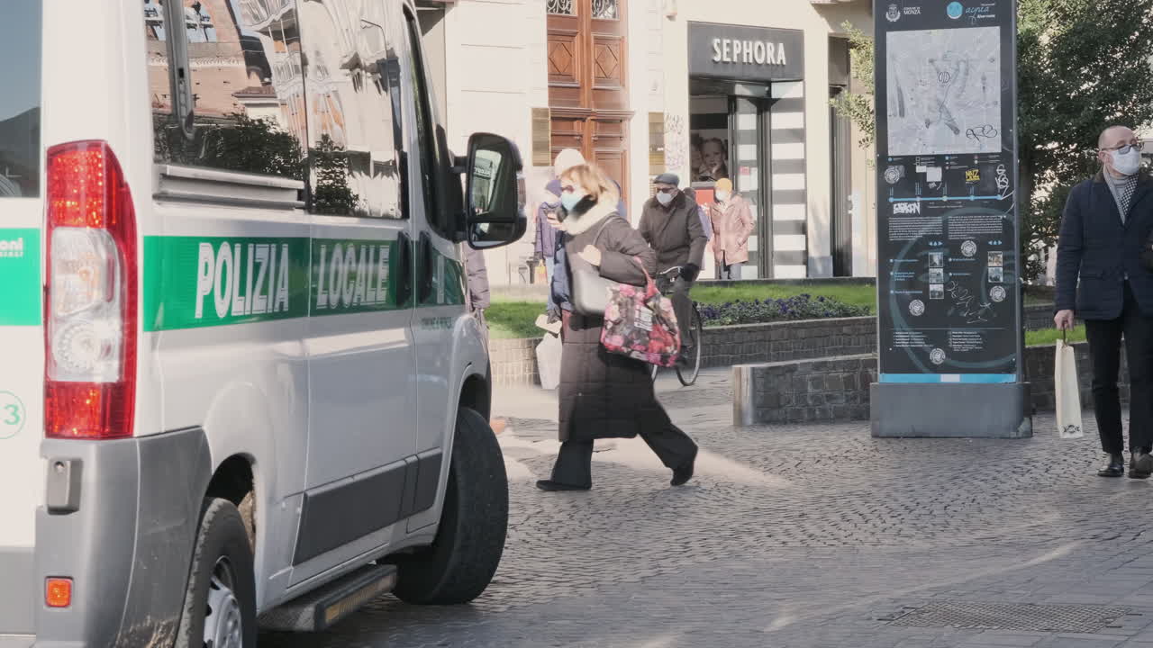 Police Officer Getting Off The Van And Walks On The Street. Police Visibility In Monza, Northern Italy At Daytime. full shot