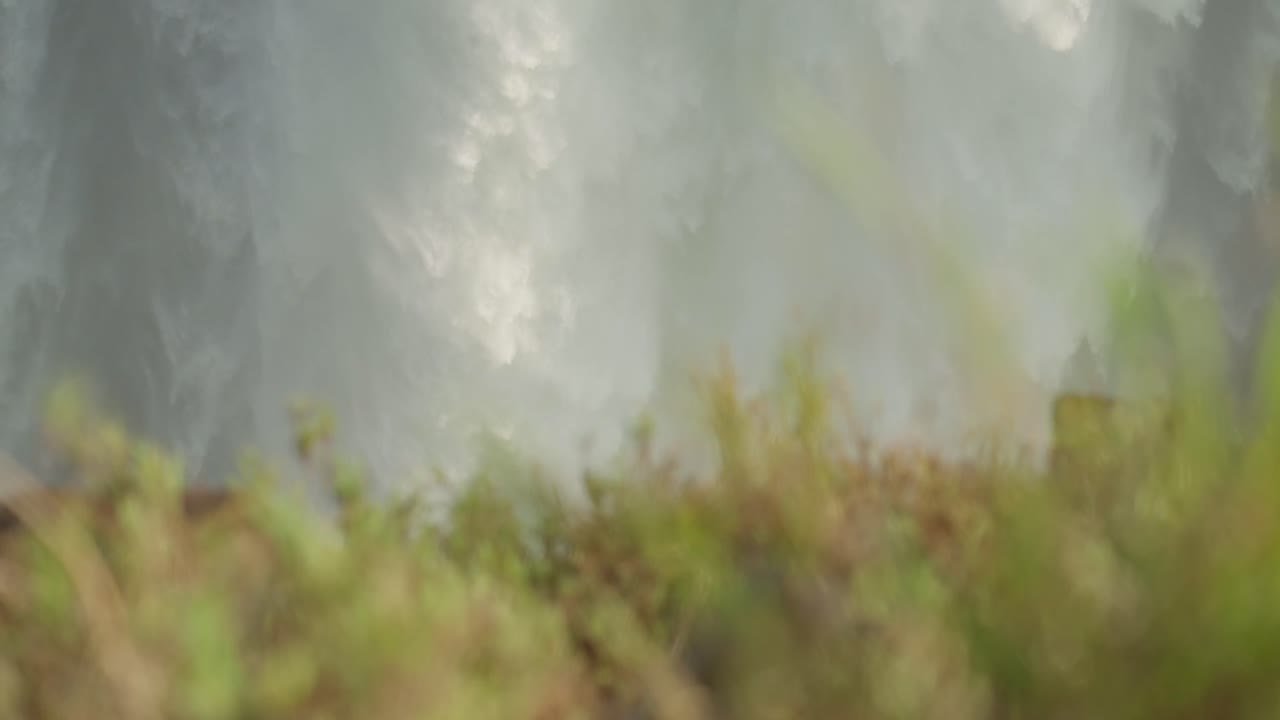 빅토리아 폭포 짐바브웨 물은 느린 동작으로 가까이에서 흐르고 있습니다.