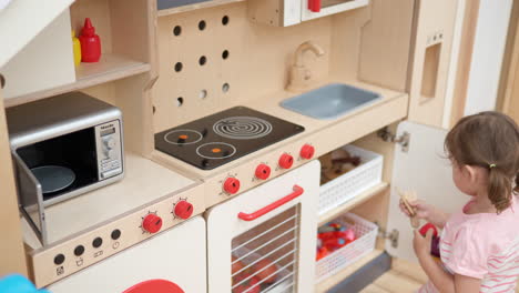 Caucasian-Girl-Toddler-Playing-in-Toy-Kitchen