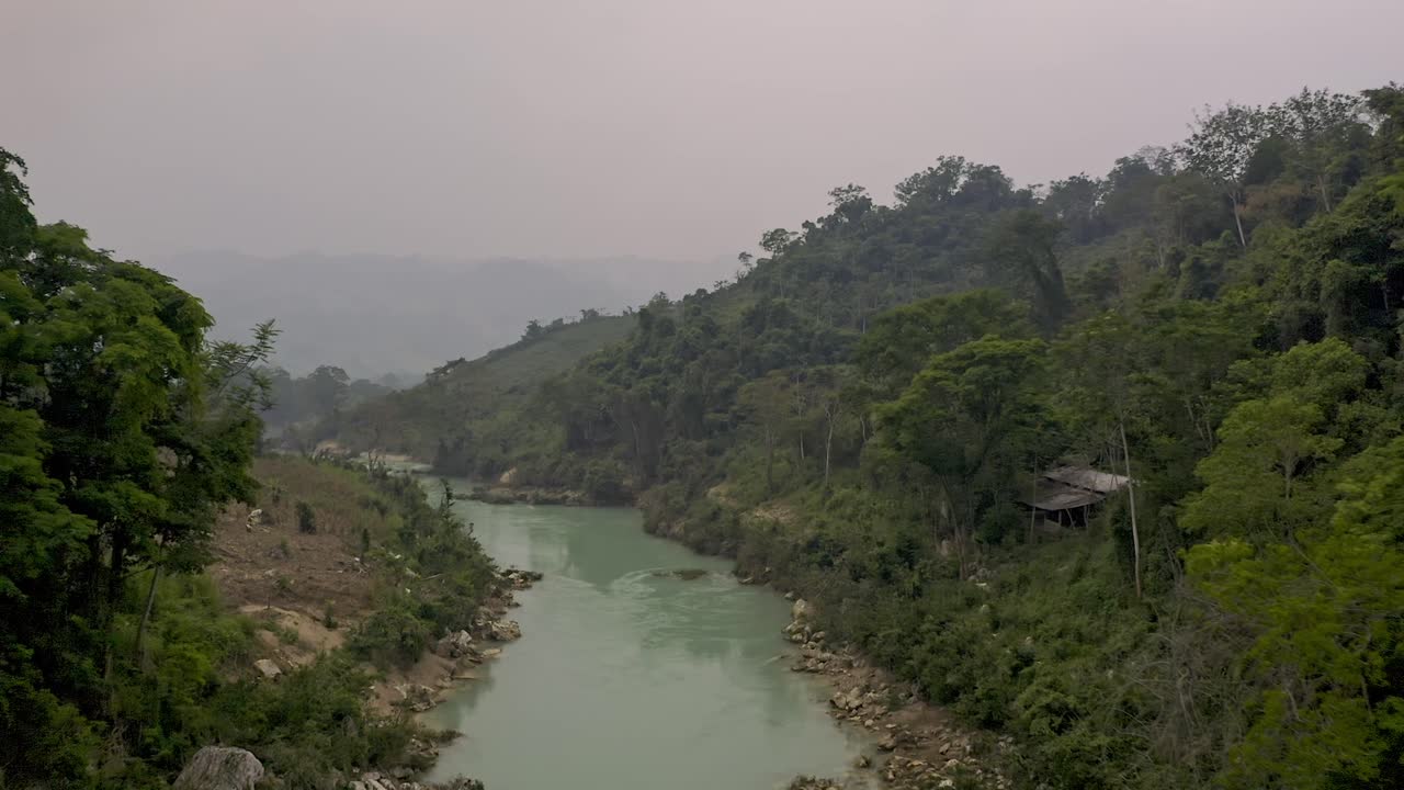 Aerial drone shot of the Agua Clara river in Chiapas, Mexico. The captures the river's distinctive pale turquoise water as it winds through a vast and lush landscape of green jungle