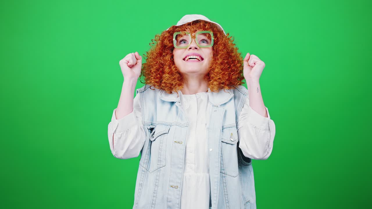 finalmente ganar. joven feliz pelirroja mujer rizada con gafas y sombrero de panama animando sinceramente, disfrutando del éxito