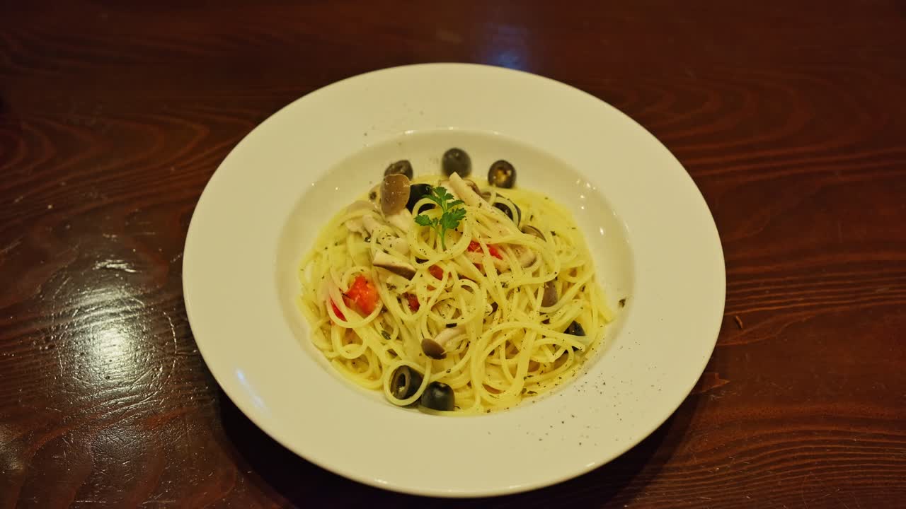 Spaghetti con funghi, pomodoro e olive, cibo italiano in Giappone.