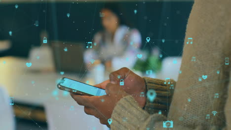 animación de la red de medios sobre las manos de un hombre afroamericano usando un teléfono inteligente en una oficina casual
