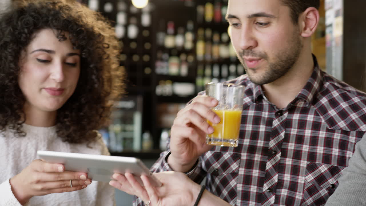 jóvenes adultos usando tabletas en un café