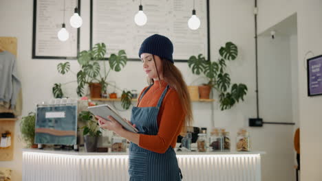woman working in a cafe using a tablet