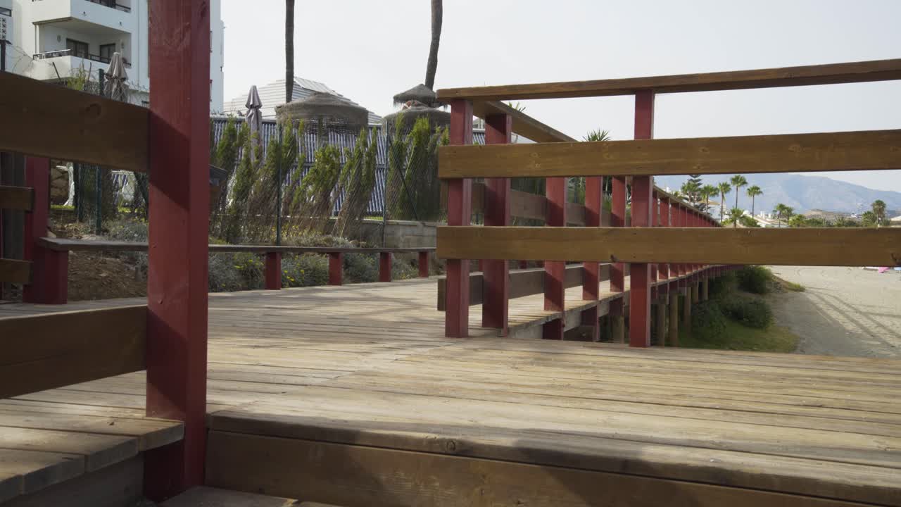 Walking up the wooden steps of the boardwalk on a beautiful sunny day on La Cala de Mijas Beach on the Costa Del Sol