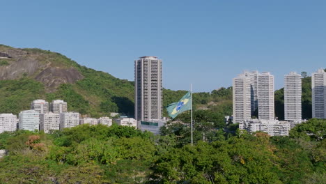 Imágenes-Aéreas-En-Cámara-Lenta-Girando-Alrededor-De-La-Bandera-De-Brasil-Moviéndose-En-El-Viento-En-El-Parque-Yitzhak-Rabin-En-Río-De-Janeiro