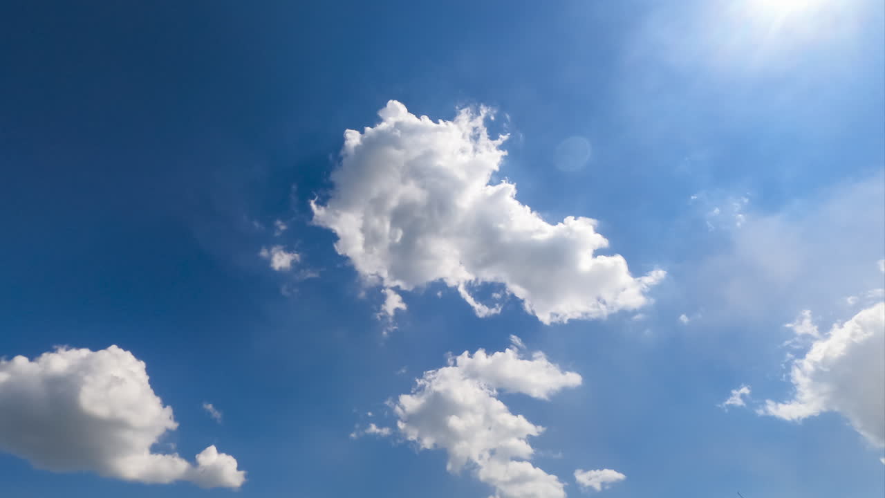 Beautiful soft light clouds transforming in the bright rays of summer sun. Low angle view timelapse.