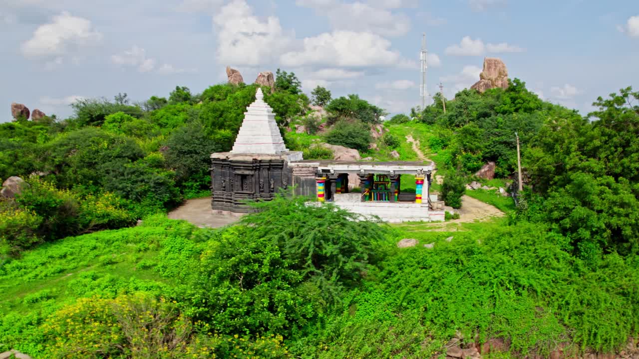Thumbureshwara Devalayam with signal tower in the background and trees at yelupu Gonda, Surampally, tekmal, Telangana, india. day time, semi orbit, drone shot, 4k.