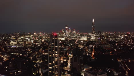 Absteigender-Und-Nach-Oben-Geneigter-Schuss-Der-Nächtlichen-Skyline.-Panoramablick-Auf-Das-Stadtbild-Mit-Einer-Gruppe-Von-Wolkenkratzern-Im-Geschäftszentrum-Der-Stadt.-London,-Vereinigtes-Königreich