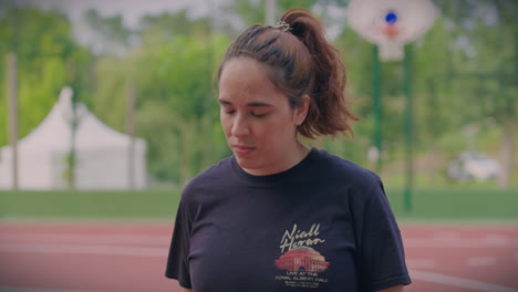 girl practices basketball in outdoor cort close shot