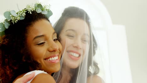 Bride-under-veil-hugging-bridesmaid-happily-4K-4k