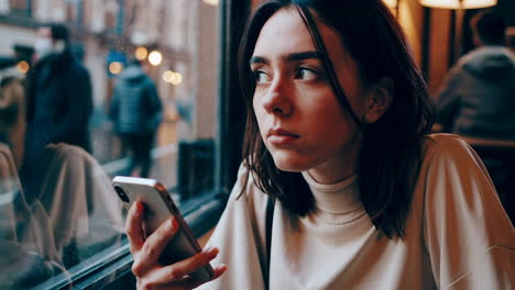 mujer joven usando un teléfono inteligente en un café